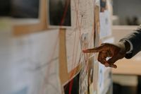 Close-up shot of a person pointing at an evidence board